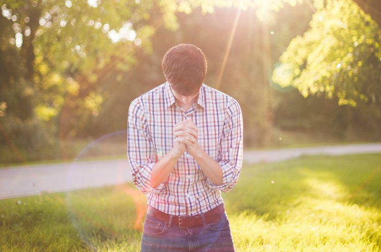 хлопець склонився у молитві